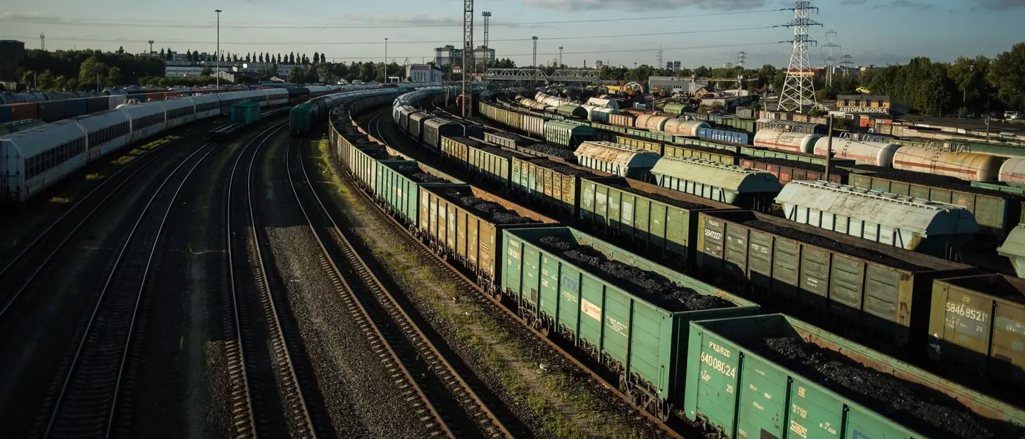 Freight wagons on rail tracks in a yard at dusk