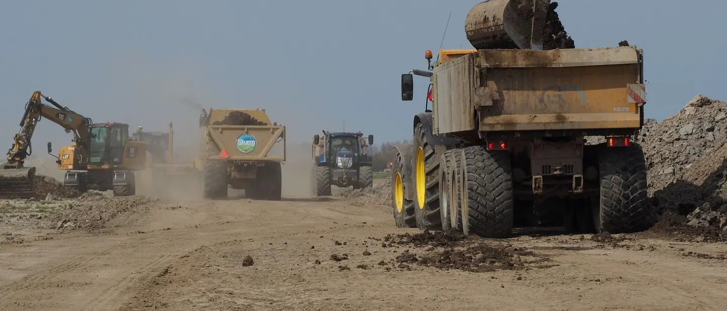 Excavator loading a dump truck at an earthworks site